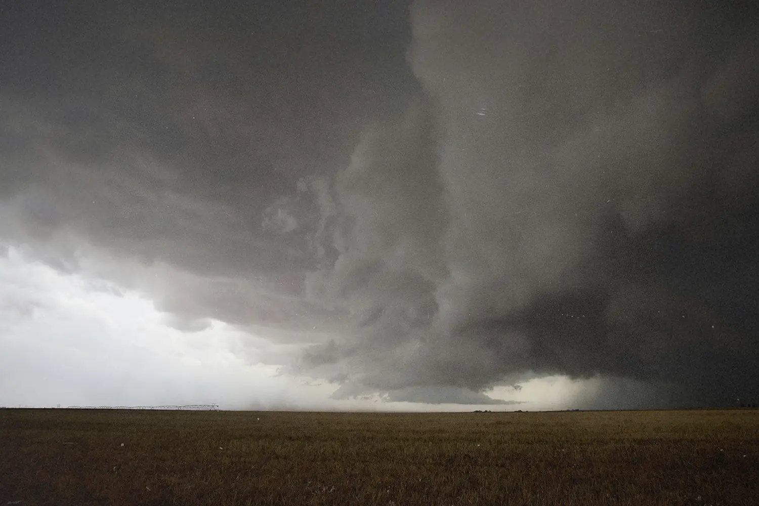 Grey skies over open field