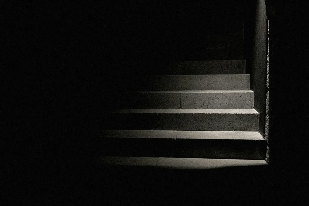 spotlight shining in a dark room on concrete stair steps