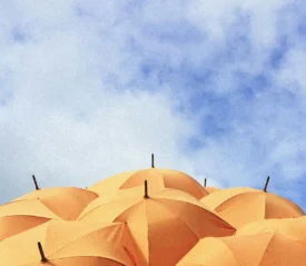 orange umbrellas under a cloudy sky