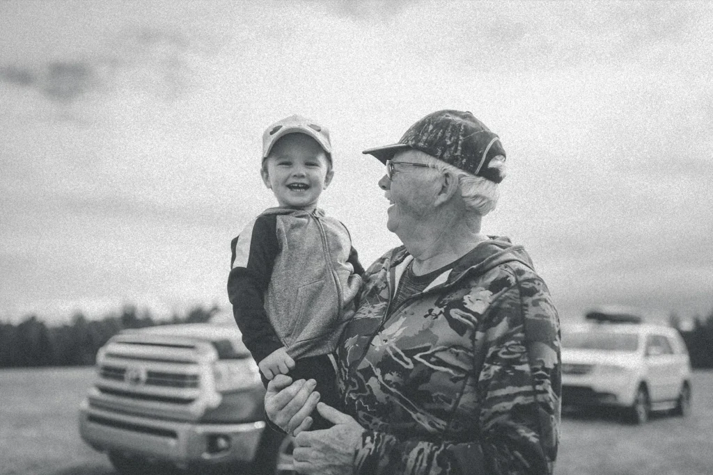 older man holding a smiling little boy