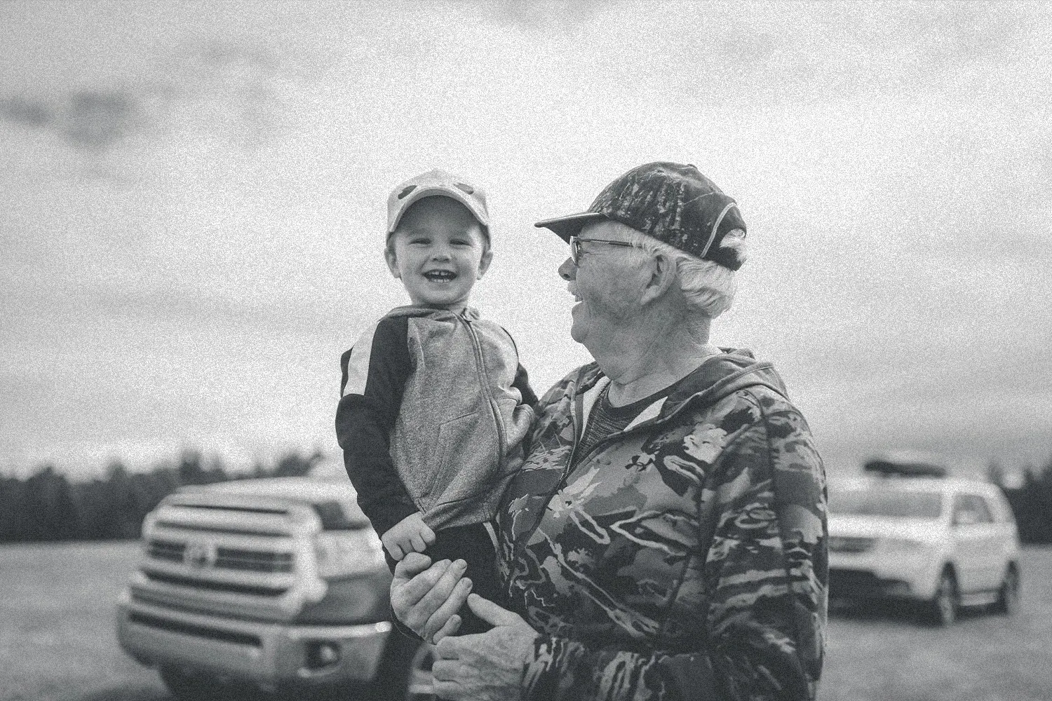 older man holding a smiling little boy