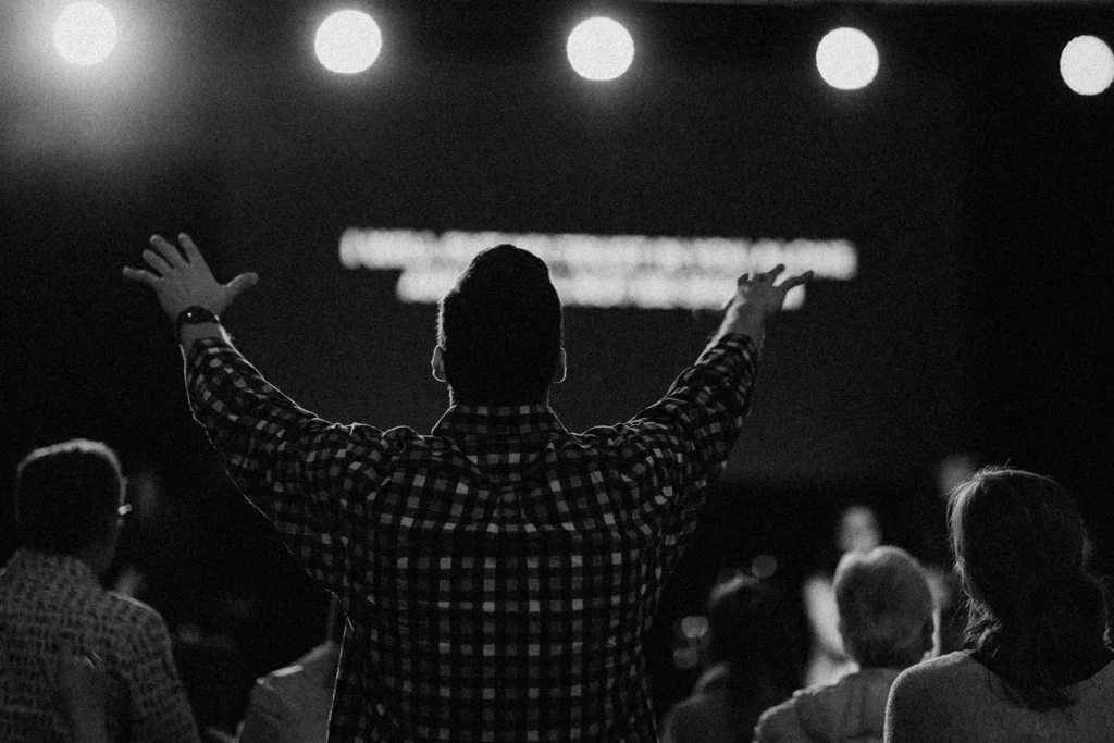 man with hands raised in prayer