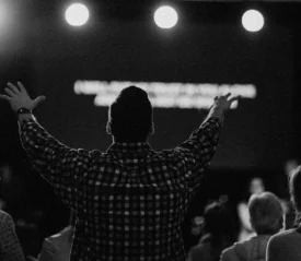 man with hands raised in prayer