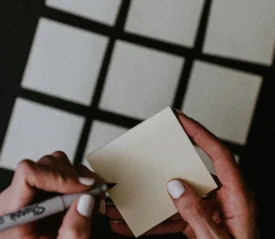 woman poised to write on a white card