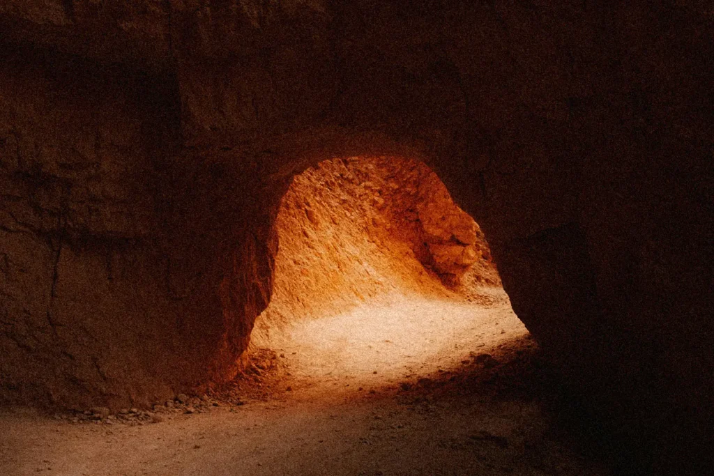 sun peeking into the opening of a cave