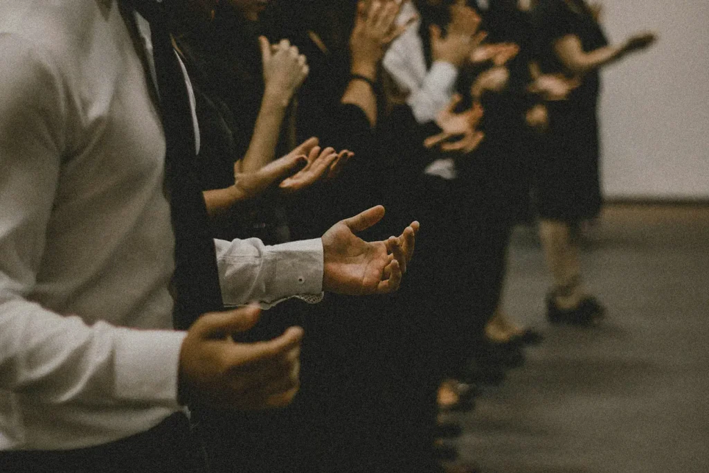 Line of people with hands lifted in prayer