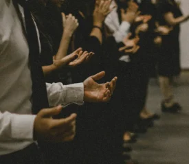 Line of people with hands lifted in prayer
