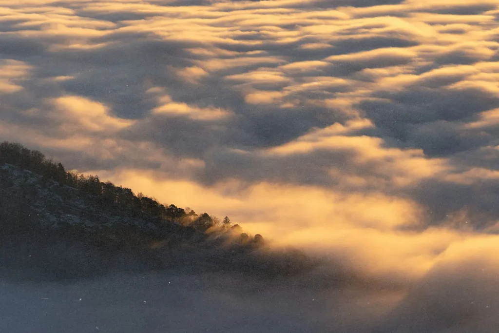 Bed of clouds resting on mountain top
