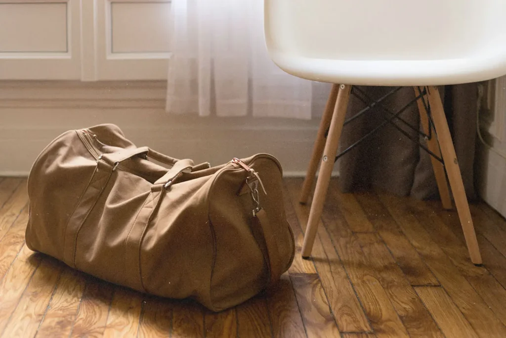duffle bag sitting on floor next to chair