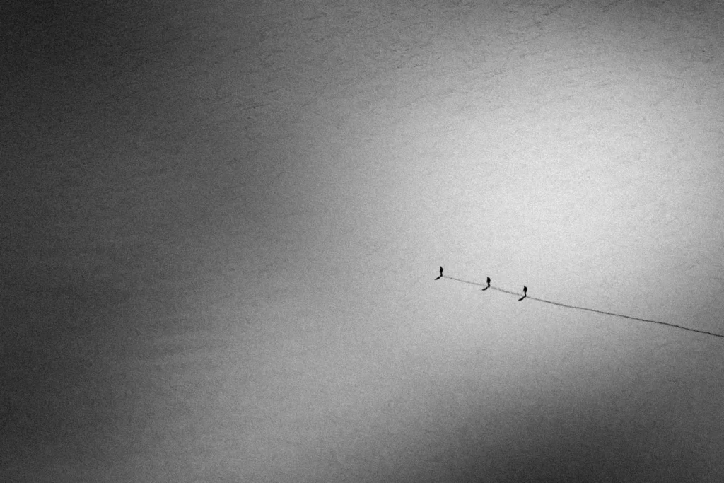 Clear open dessert with 3 people following a single line in the sand