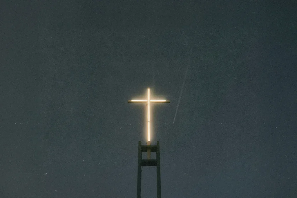 Bright neon cross shining in a dark sky