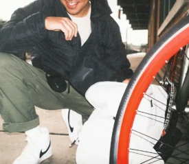 Man squatting posed next to a bike tire