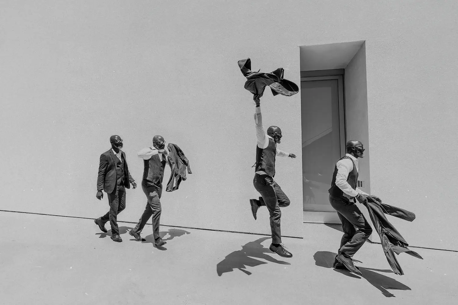 4 men in suits walking with excitement