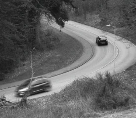 Two cars driving along a curved road