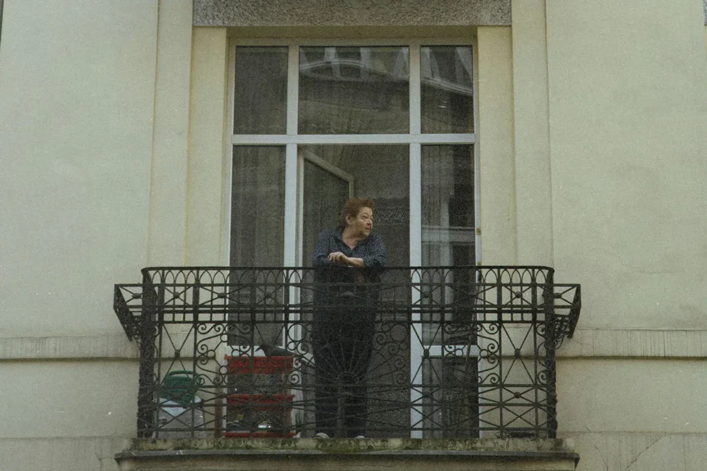 Person standing on balcony looking off into the distance
