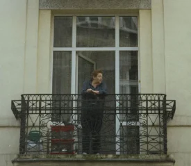Person standing on balcony looking off into the distance