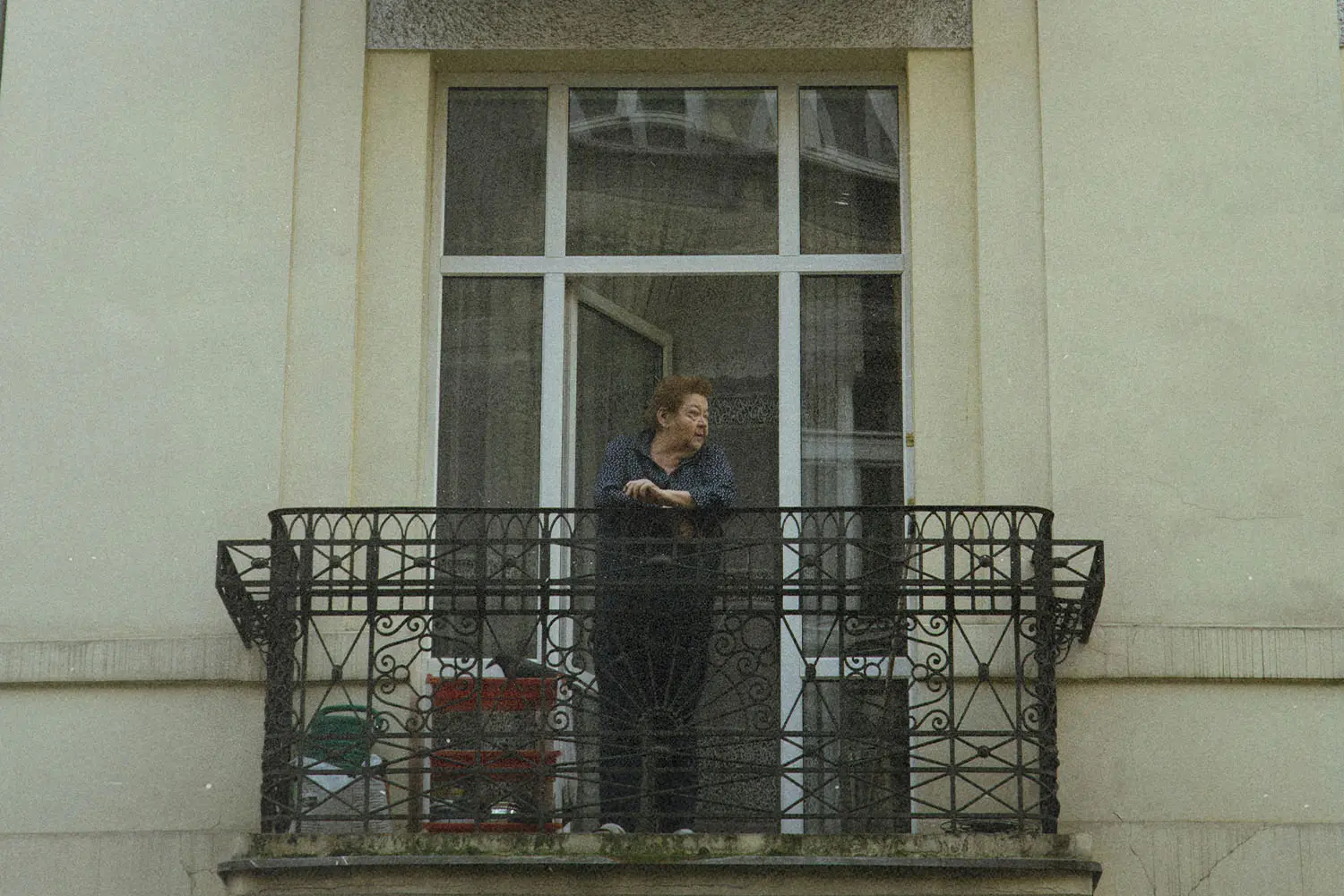 Person standing on balcony looking off into the distance