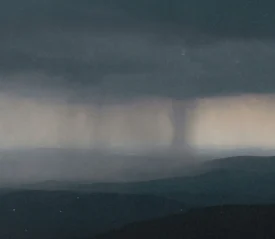 Twister forming in the background of dark gray skies