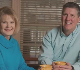 Tom and Vicki Leuther holding coffee mugs and smiling