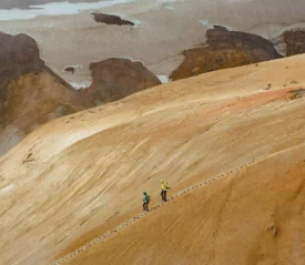 Two people walking down steps in a dessert sand dune