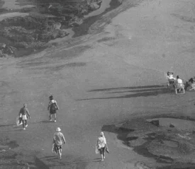 people sitting in a lawn chair at the beach