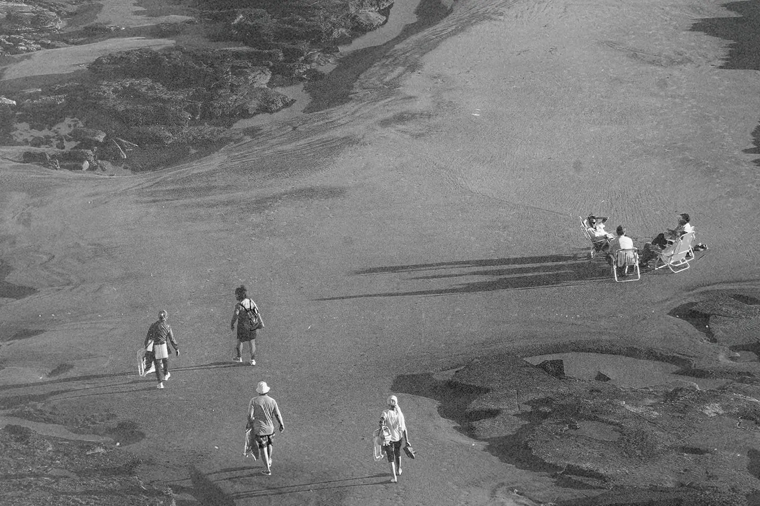 people sitting in a lawn chair at the beach
