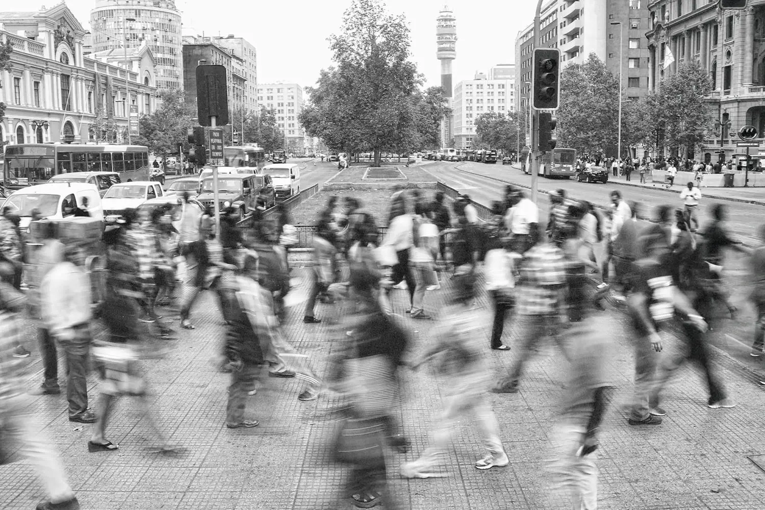 lots of people walking across a crosswalk with a blur for the look of speed