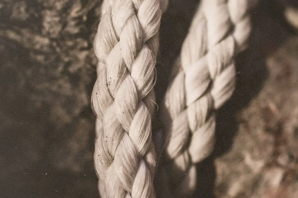 Two pieces of braided fabric resting on a wooden background