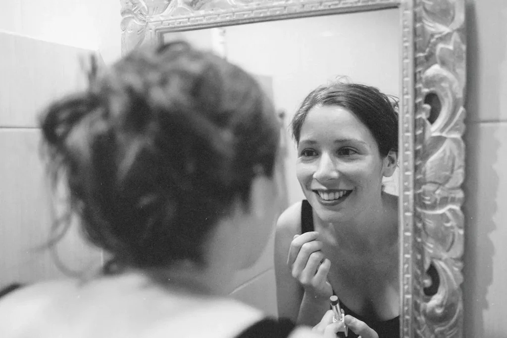 Smiling woman looking at herself in the mirror