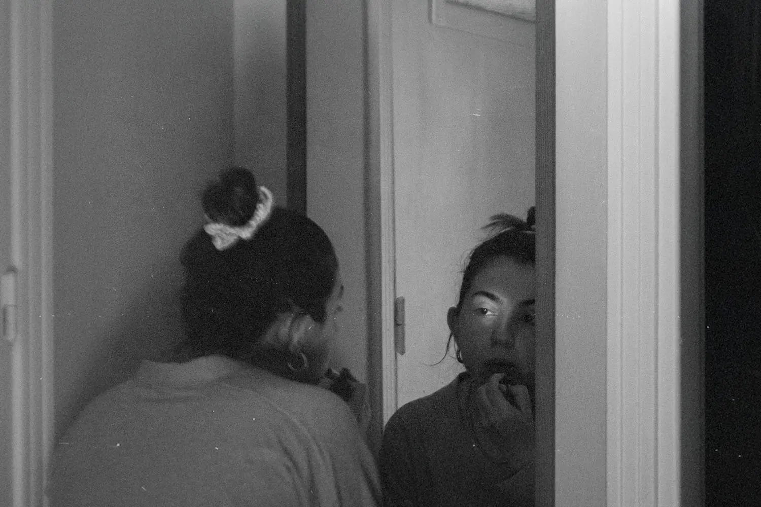 Woman leaning into a mirror putting lipstick on