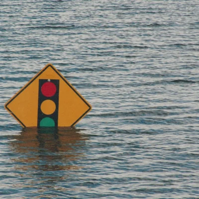 Flood waters that almost cover a traffic light sign