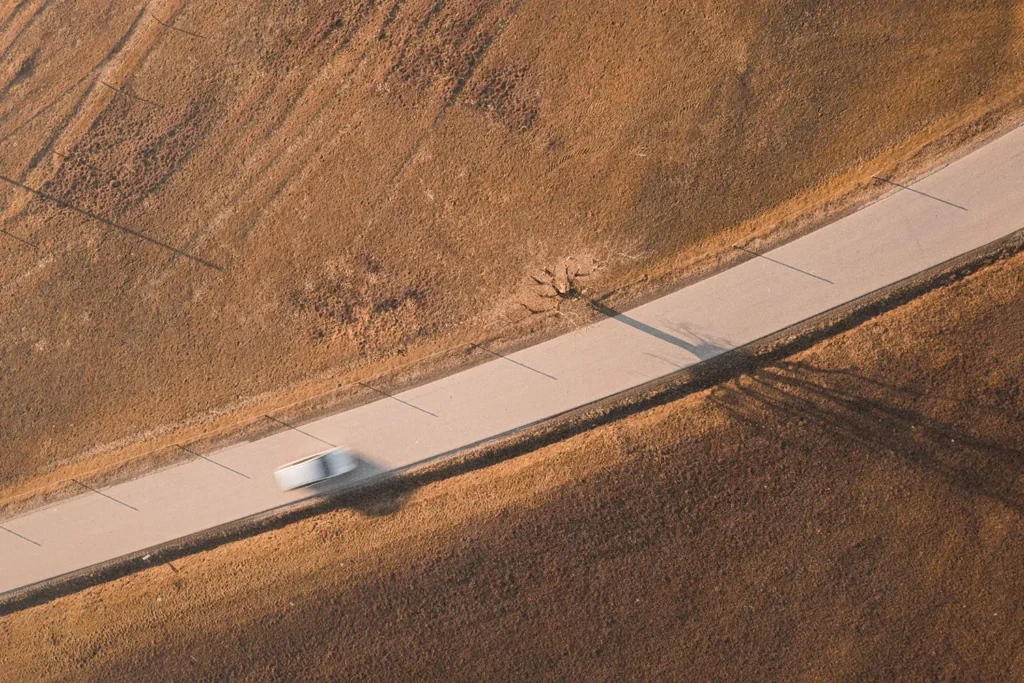 aerial view of car driving on a curving road
