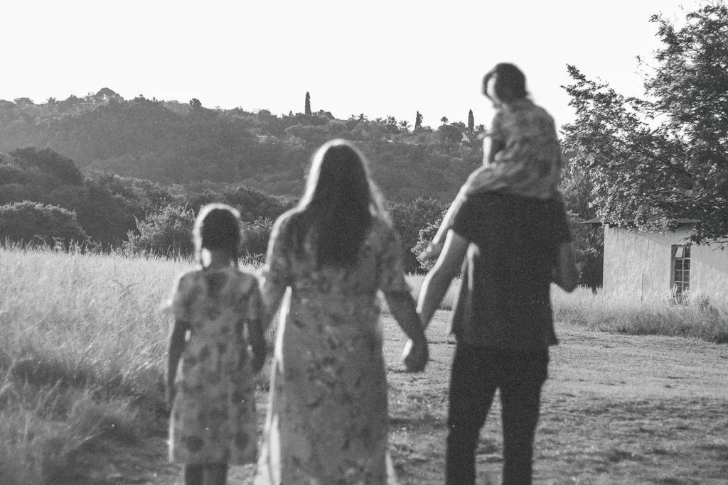 black and white photo of a family walking in a field