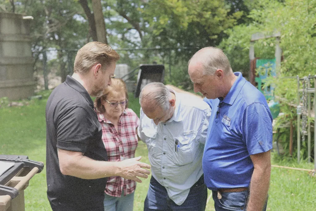 Tim Fox and Riley Stephenson laying hands and praying for couple