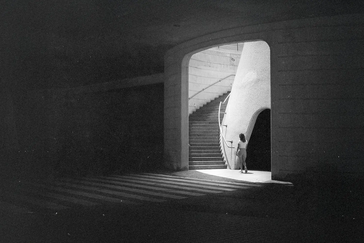 Light shining through an entryway leading to a long staircase
