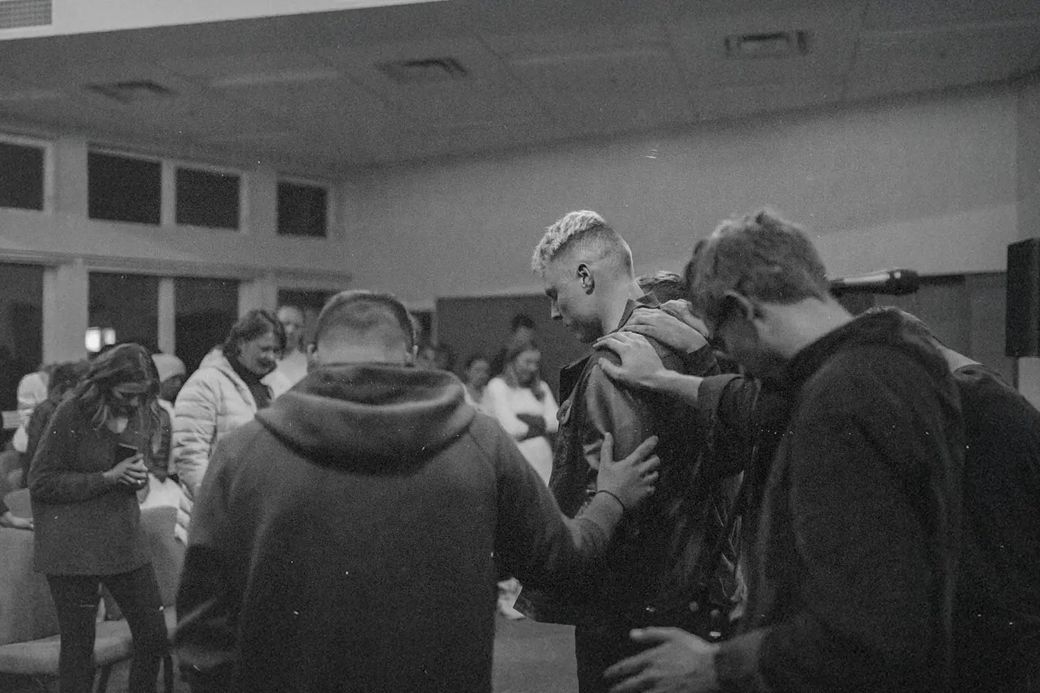 Group of people laying hands and praying for a man