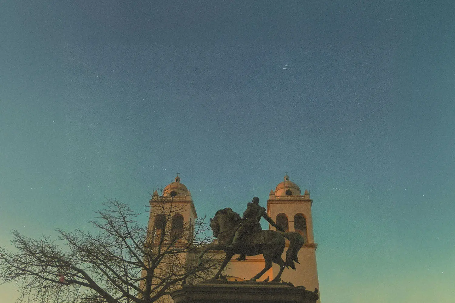 statue of guy on a horse in front of building