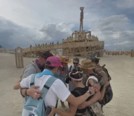 Group of people huddled in prayer at Burning Man Festival