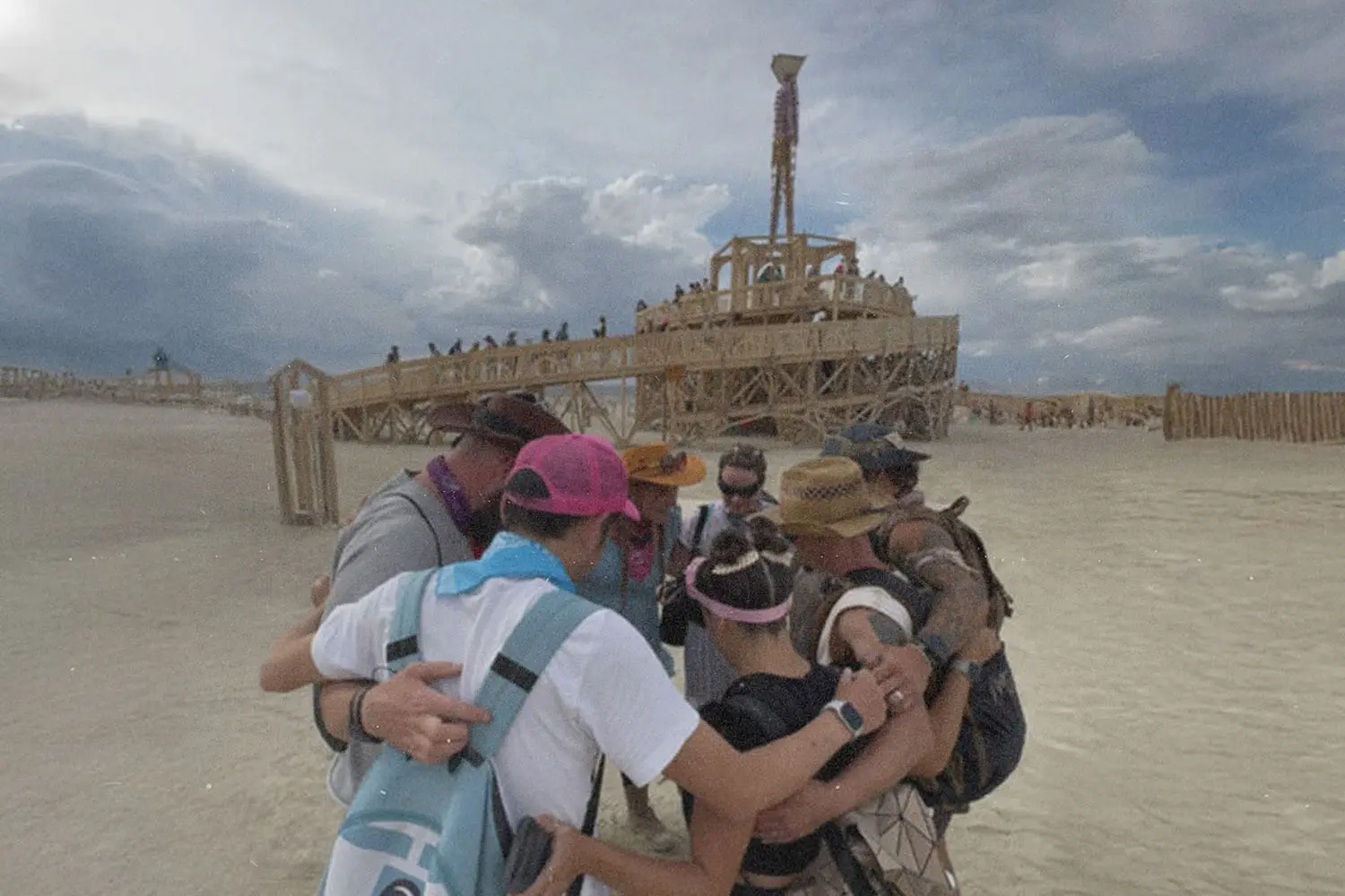 Group of people huddled in prayer at Burning Man Festival