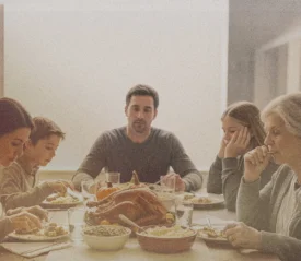 Dining table set with turkey and sides as relatives gather, a moment that reflects classic Family Drama during festive meals.