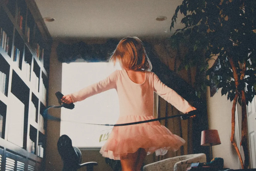 Girl playing in the living room with a jump rope.