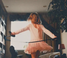 Girl playing in the living room with a jump rope.