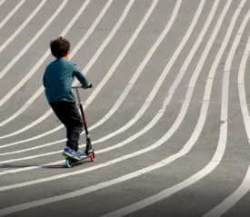 Child riding a scooter on striped pavement, symbolizing how faith helps prepare for the future with guidance and hope.