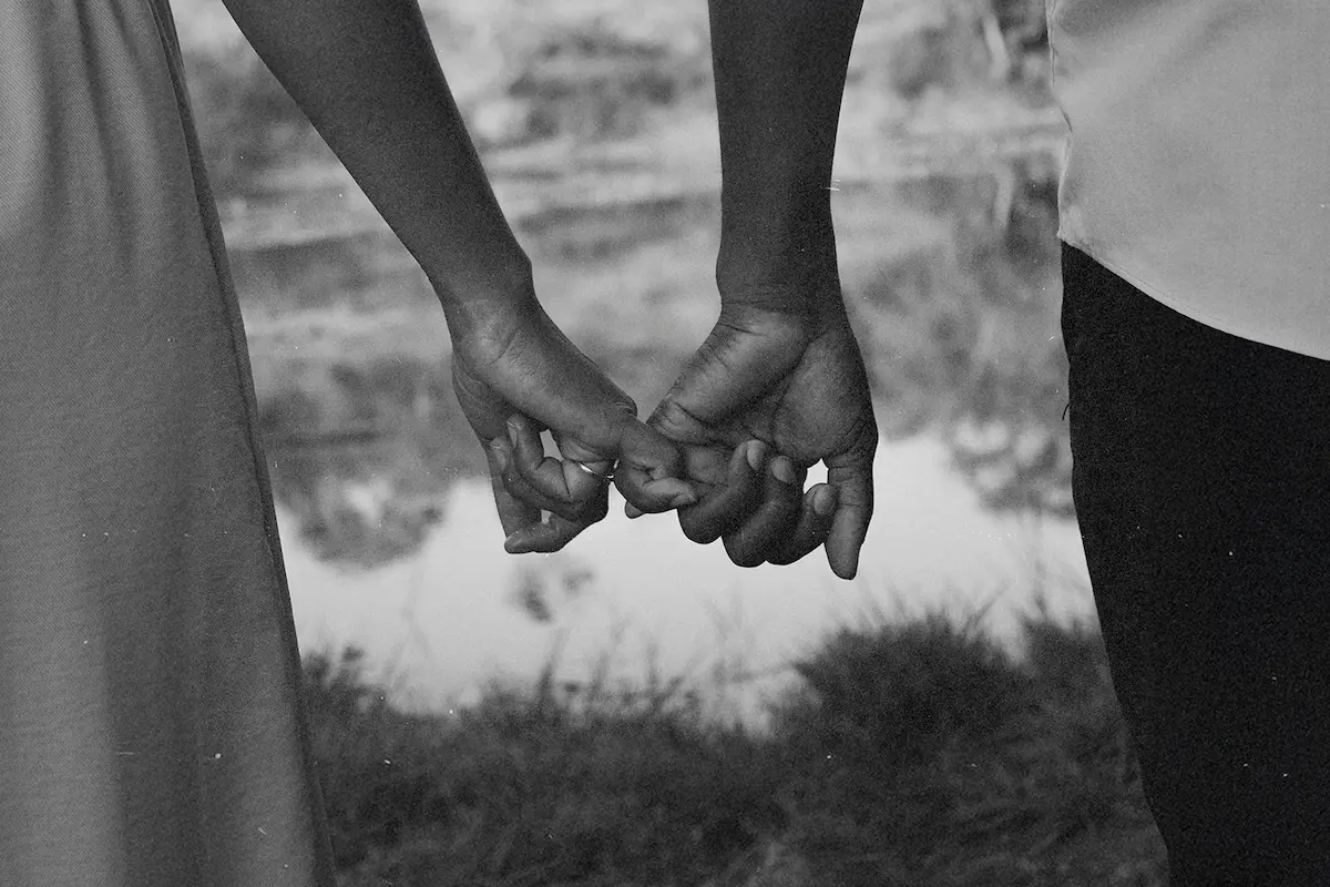 Couple holding hands by water, symbolizing a successful marriage strengthened by the power of prayer and unity in their shared testimony.