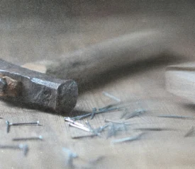 A hammer with nails on a wooden table